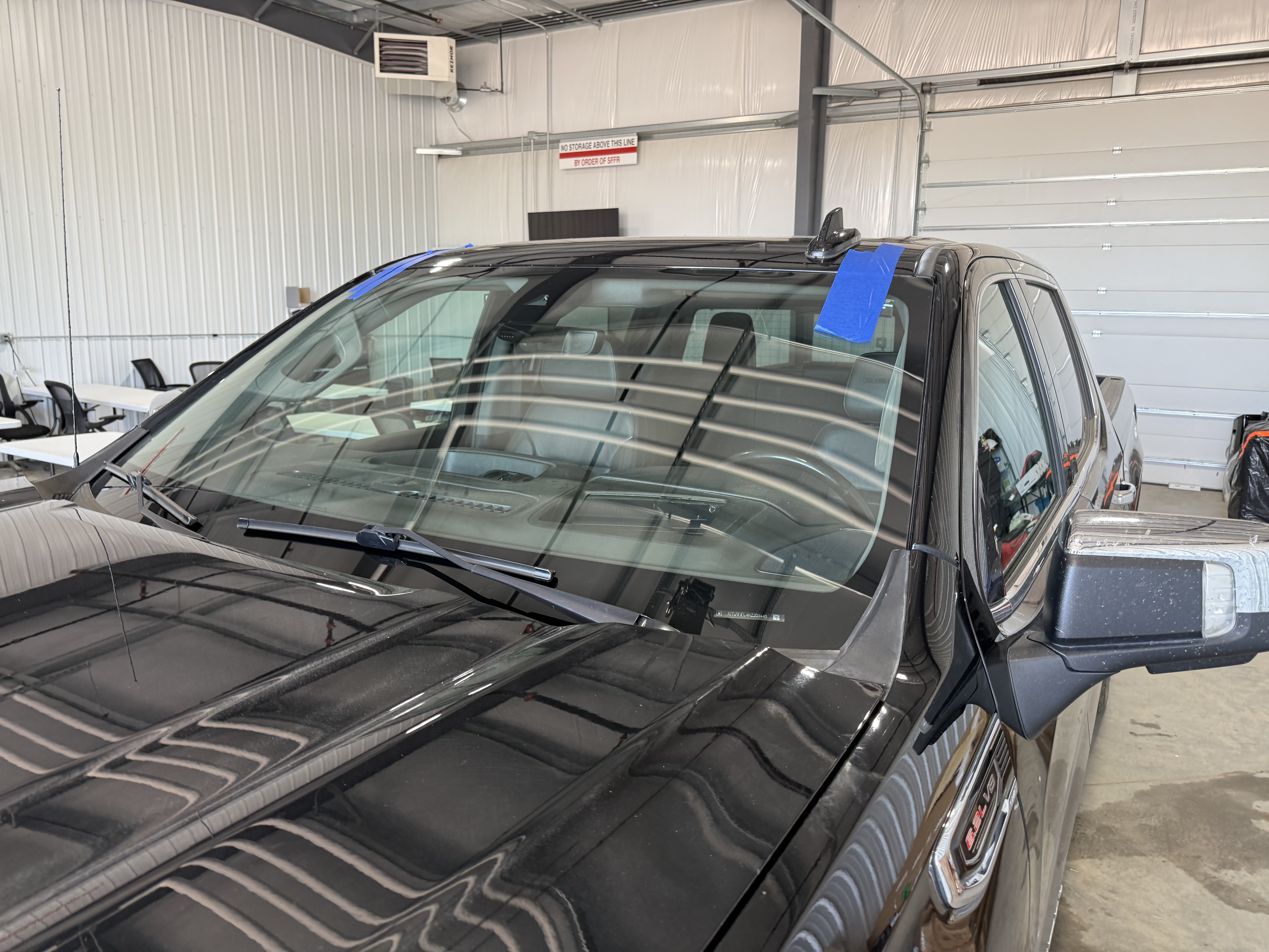 In-shop windshield replacement on black truck by Chip Doctor of Sioux Falls