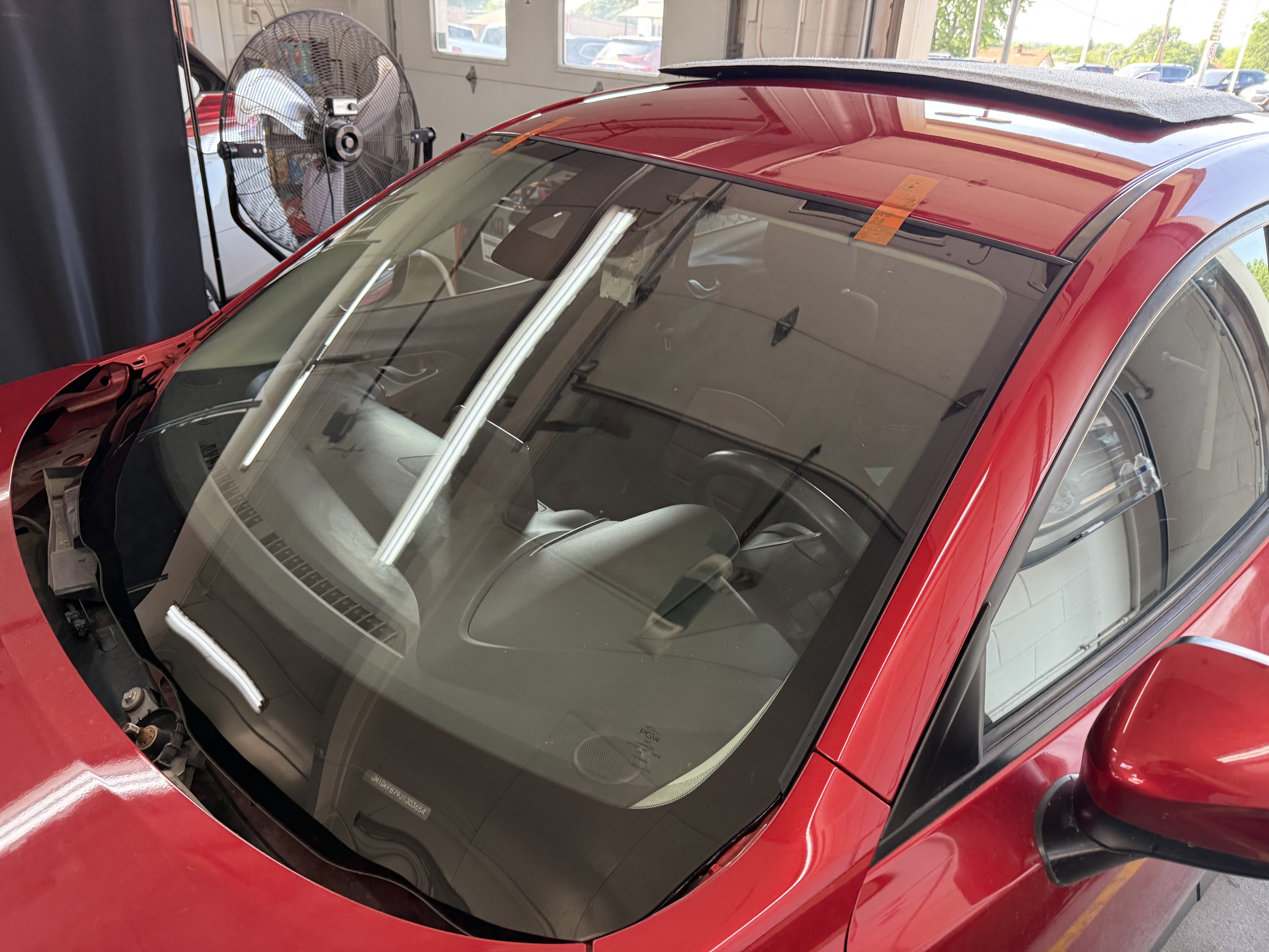 In-shop windshield replacement on red car by Chip Doctor of Sioux Falls